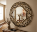 Geometric framed wall mirror reflecting a vase with dried branches.